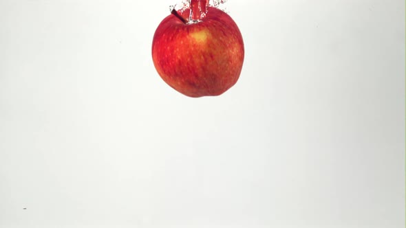 Super Slow Motion Red Juicy Apple Falls Under Water with Air Bubbles