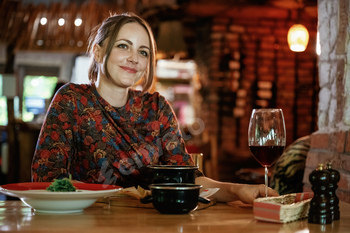 Woman is in the restaurant with food and drink