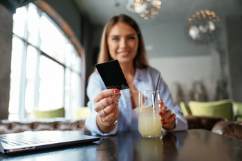 Giving the credit card. Young beautiful woman is in the restaurant