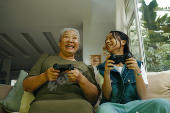 Grandma Playing Console With Her Granddaughter