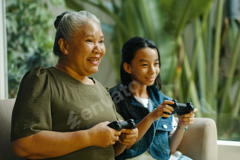 Grandma Playing Console With Grandchild