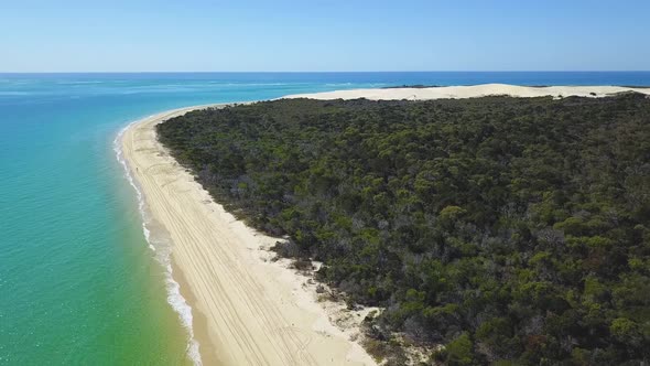 Drone footage of long white sandy beach on a calm sunny day at the Sandy Cape, Fraser Island, Queens