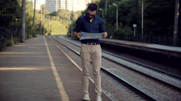 Businessman Tourist Looking On City Paper Map And Exploring City Route. Active Lifestyle On Vacation
