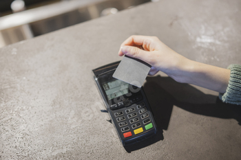 Customer Completing a Credit Card Transaction at a Retail Checkout