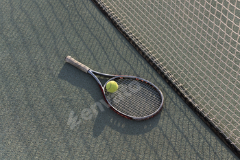 tennis racquet and ball lie on a clay tennis court, ready for a game