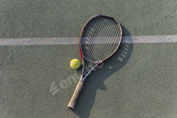 tennis racquet and ball lie on a clay tennis court, ready for a game