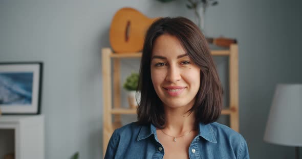 Slow Motion Portrait of Charming Young Woman Looking at Camera Smiling at Home