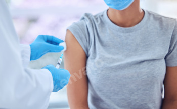 Doctor wiping the arm of a patient with cotton ball. Doctor preparing a patient for injection with