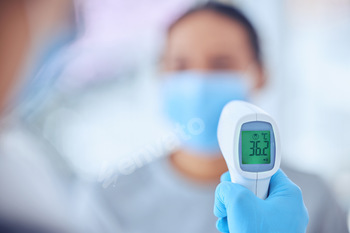 Hand of a doctor holding a thermometer. Closeup on hand of doctor holding a thermometer. Doctor usi