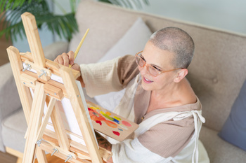 Senior woman focused on painting a canvas masterpiece