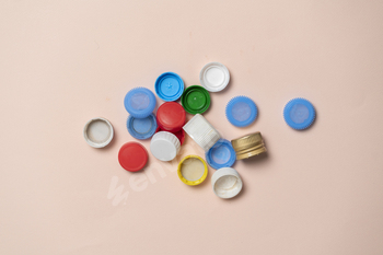 a pile of colorful plastic caps for bottles on color table