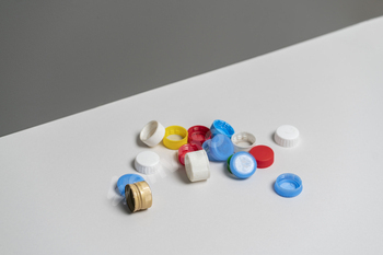 a pile of colorful plastic caps for bottles on color table