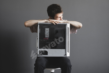 a young male person holding a new gamer pc desktop computer