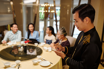 Waiter Writing Order In Notebook