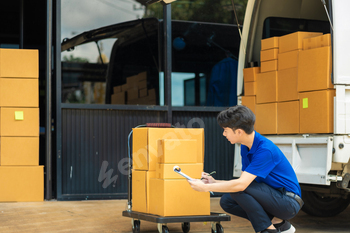 Asian delivery man, delivery men unloading cardboard boxes from truck.