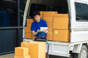 Asian delivery man, delivery men unloading cardboard boxes from truck.