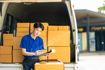 Asian delivery man, delivery men unloading cardboard boxes from truck.