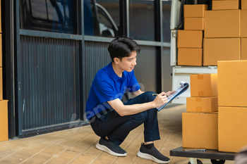 Asian delivery man, delivery men unloading cardboard boxes from truck.