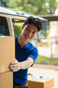 Asian delivery man, delivery men unloading cardboard boxes from truck.