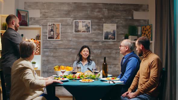 Woman at Dinner with Friends and Family Having a Surprise with Cake