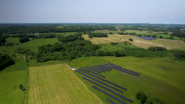 Drone footage of countryside with solar panel field.