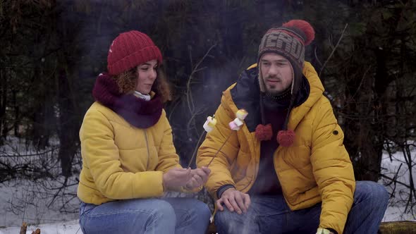 Young Man and Woman on a Picnic in the Winter Forest