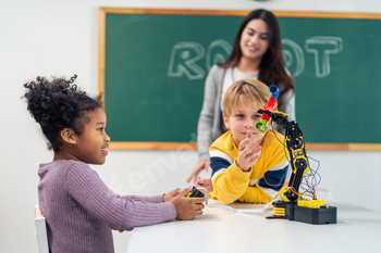 Adorable student learn with teacher in classroom at elementary school.