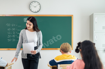 Group of student learn with teacher in classroom at elementary school.