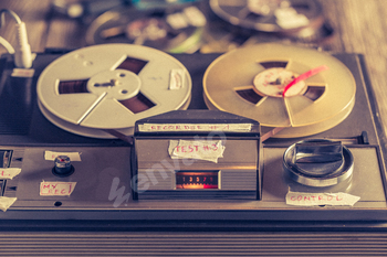 Vintage reel audio recorder and a used rolls of tape.