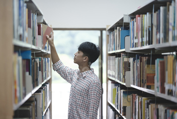 Man Searching for a Book in the Library