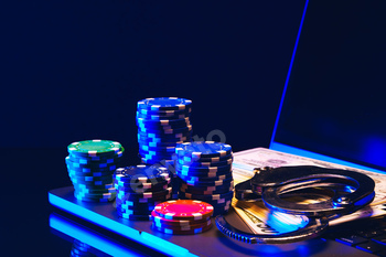 Stacks of Casino Chips and Handcuffs on Laptop Keyboard