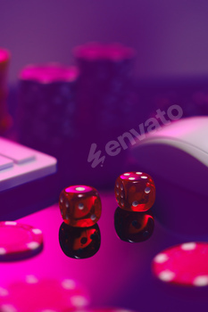 Red Dice on a Pink Surface With a Computer Keyboard and Mouse