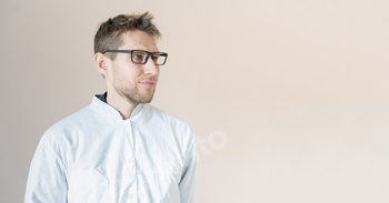 a young male medical worker, doctor in white uniform, confident doctor