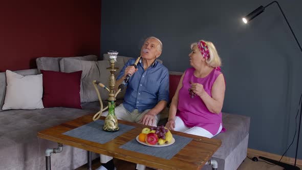 Elderly Couple Smoking Hookah at Home. Senior Grandmother and Grandfather Having Fun, Relaxing