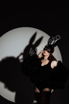 A woman in a black outfit with a rabbit mask on her face