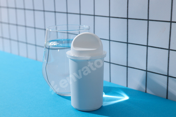 A water filter with a glass on a light background