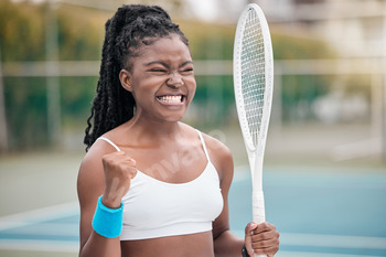 Excited woman cheering after a tennis match. Young tennis player enjoying a game of tennis on the c