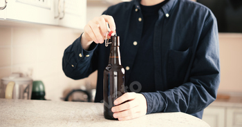 a man open the glass beer bottle on party, bad habit, alcohol addict