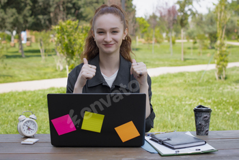 Girl, freelancer, student, working at laptop in park, showing super.