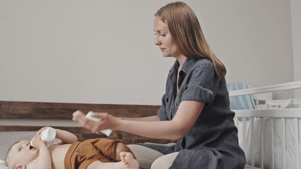 Woman Putting Moisturizer on Toddler