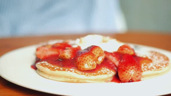 Close up pancake with strawberries, whip cream at cafe.