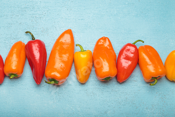 Fresh peppers forming a line on blue background