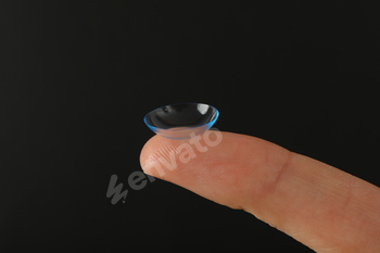 Close-up of a clear contact lens on a fingertip