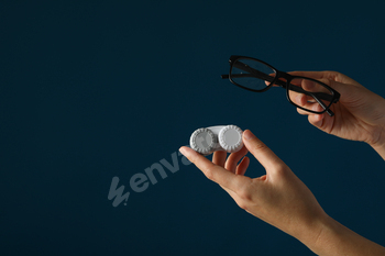 Glasses and a container for contact lenses in hands