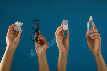 Glasses and a container for contact lenses in hands