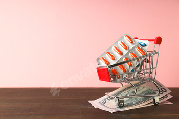 Pills in shopping cart, medical corruption concept.