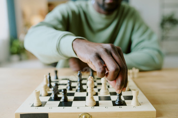 Unrecognizable Man Solving Chess Puzzle