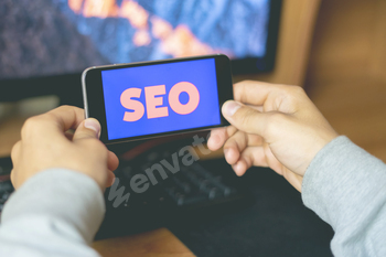 young male worker holding a smartphone with SEO text design in the office, search engine