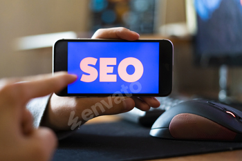 young male worker holding a smartphone with SEO text design in the office, search engine