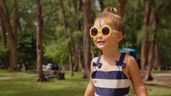 Adorable Little Girl Dancing and Smiling in the Garden on a Warm and Sunny Summer Day